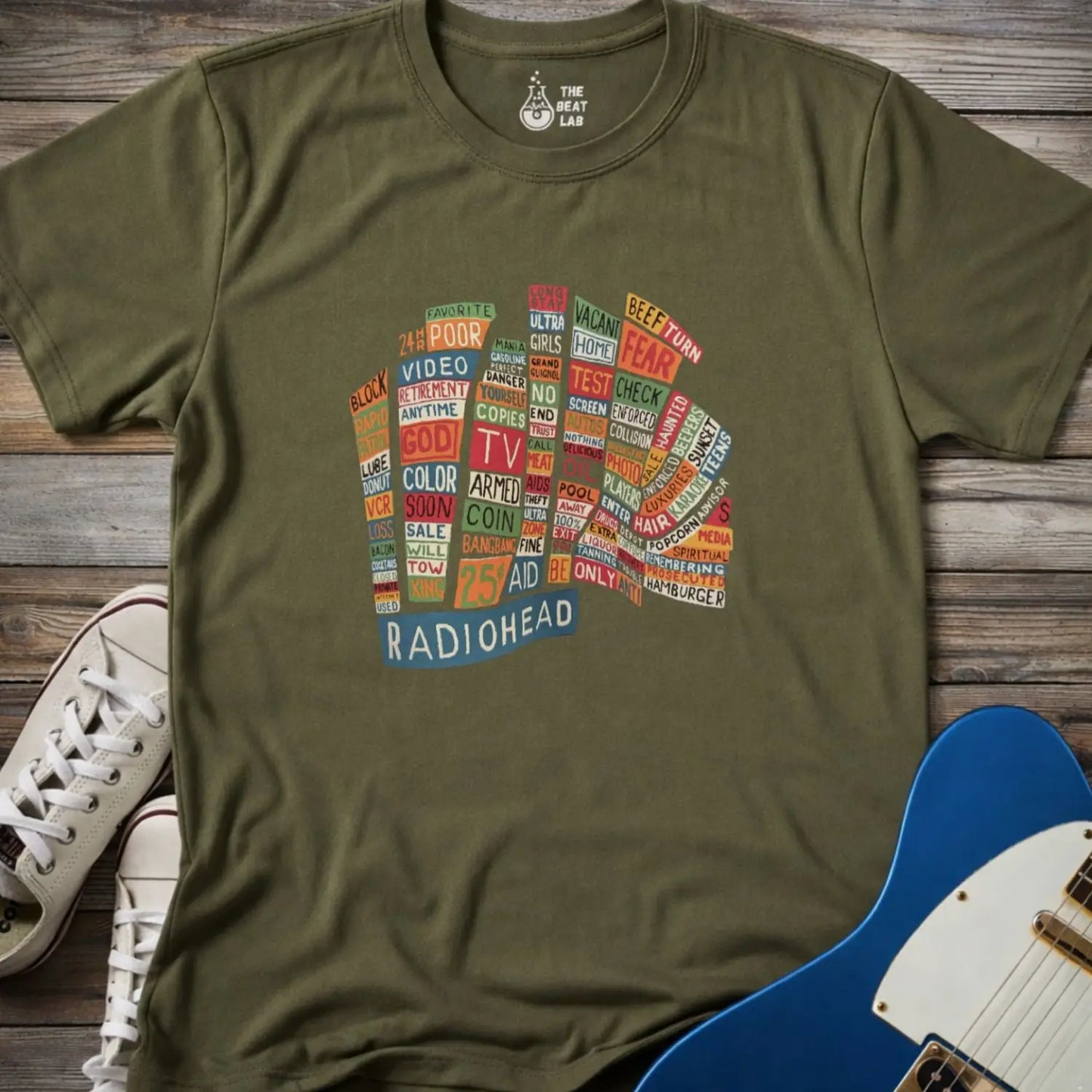 Military green color adult unisex t-shirt gildan 64000 Radiohead Hail to the Thief graphic t-shirt featuring a bear-shaped block of colorful words and a RADIOHEAD label beneath.