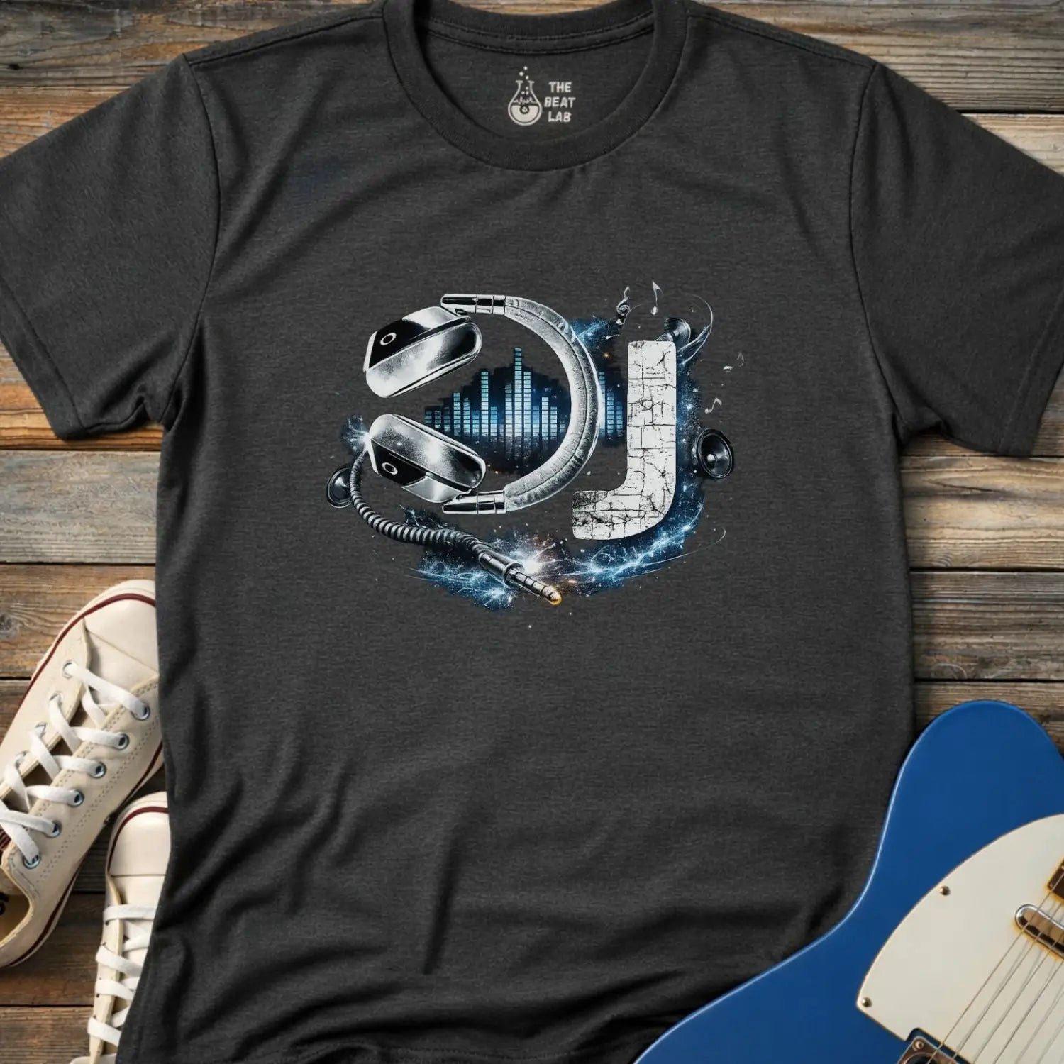 DJ letter graphic with metallic headphones, equalizer bars, speakers, music notes, and audio jack cable design on a dark heather adult men women gildan 64000 shirt