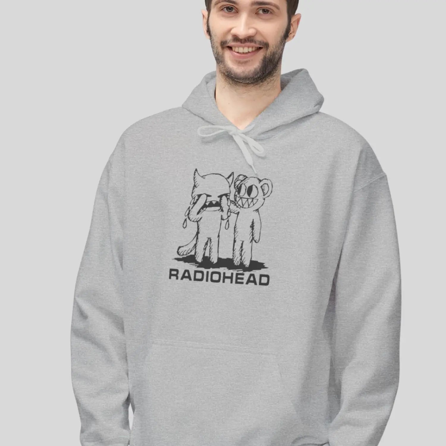 Man wearing pullover gildan hoodie with white bear character artwork graphic and “Radiohead” text design.