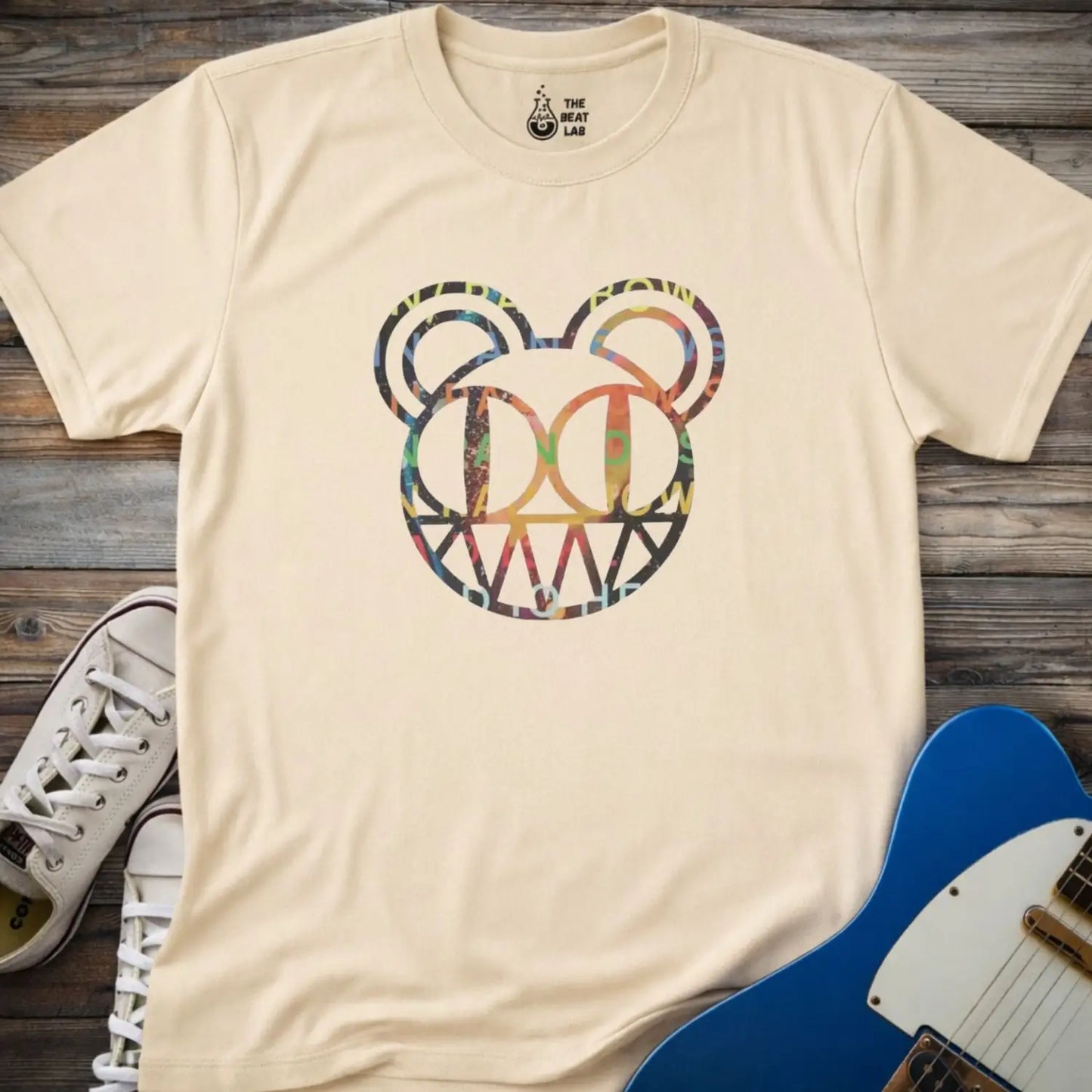 Sand beige unisex color Radiohead bear logo collage t-shirt with the iconic cartoon bear head combined with colorful album-inspired artwork for rock fans.