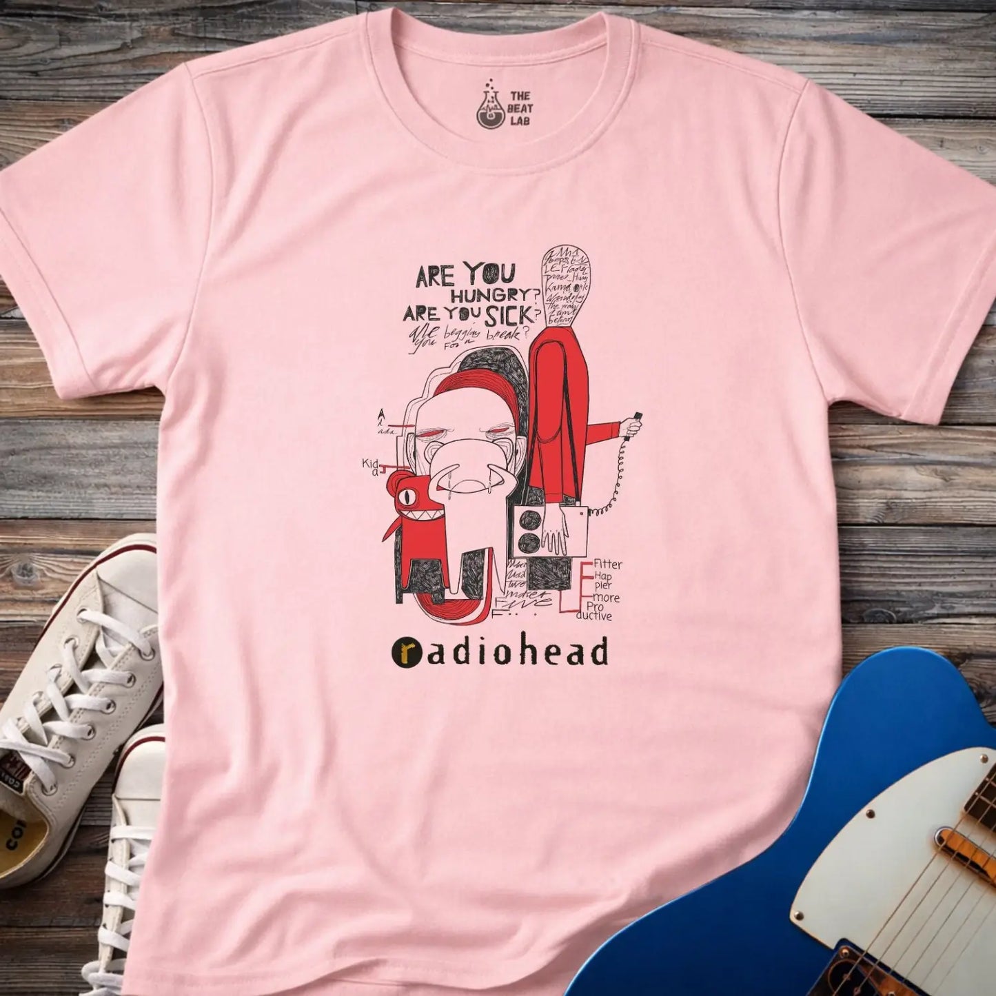 Light pink color adult unisex t-shirt gildan 64000  Radiohead comic sketch t-shirt with abstract cartoon figures in red/black line art and ‘Are you hungry? Are you sick?’ text above stylized band name.