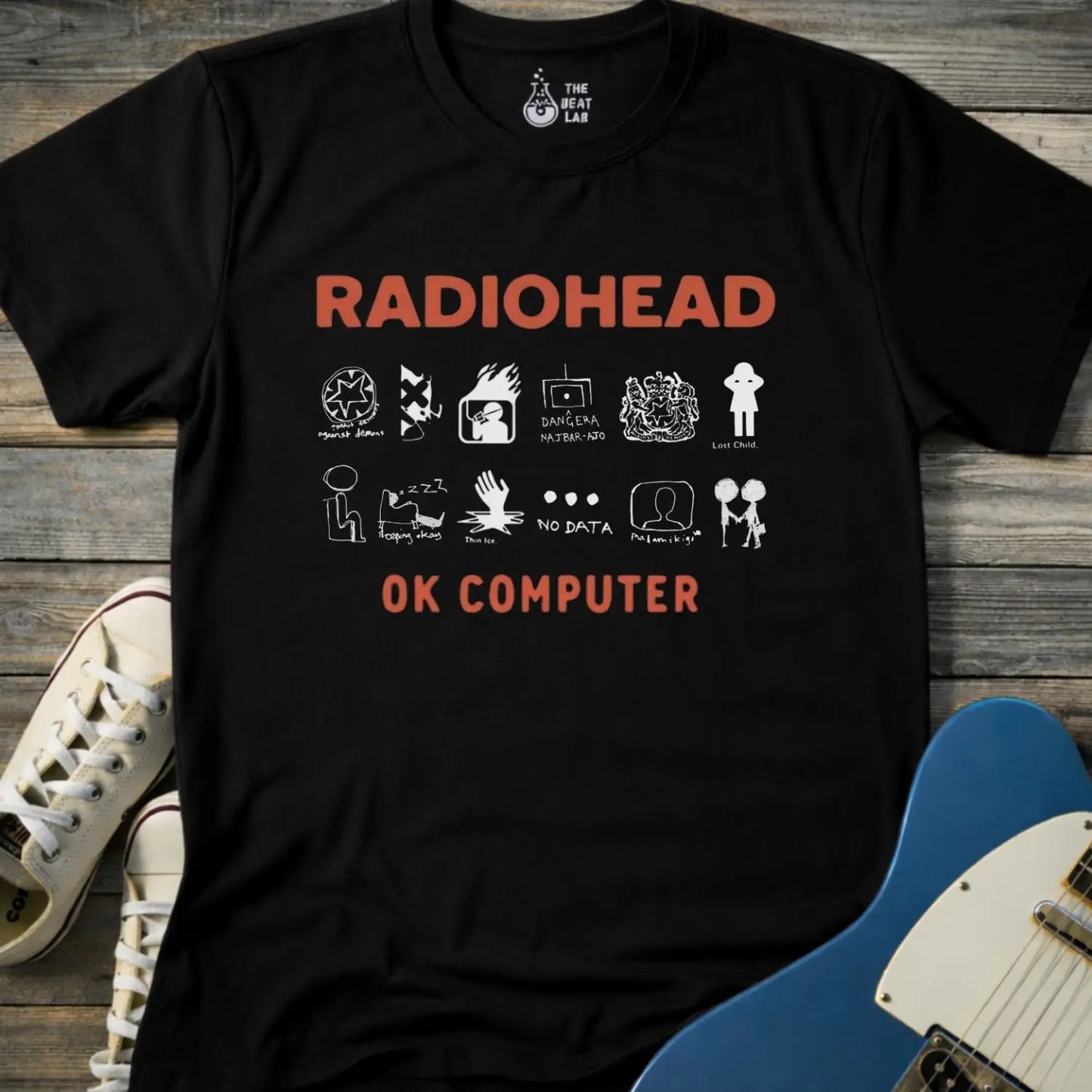 Black color adult unisex t-shirt gildan 64000 Radiohead OK Computer graphic t-shirt with large RADIOHEAD and OK COMPUTER text and a horizontal row of minimalist white icons in between.