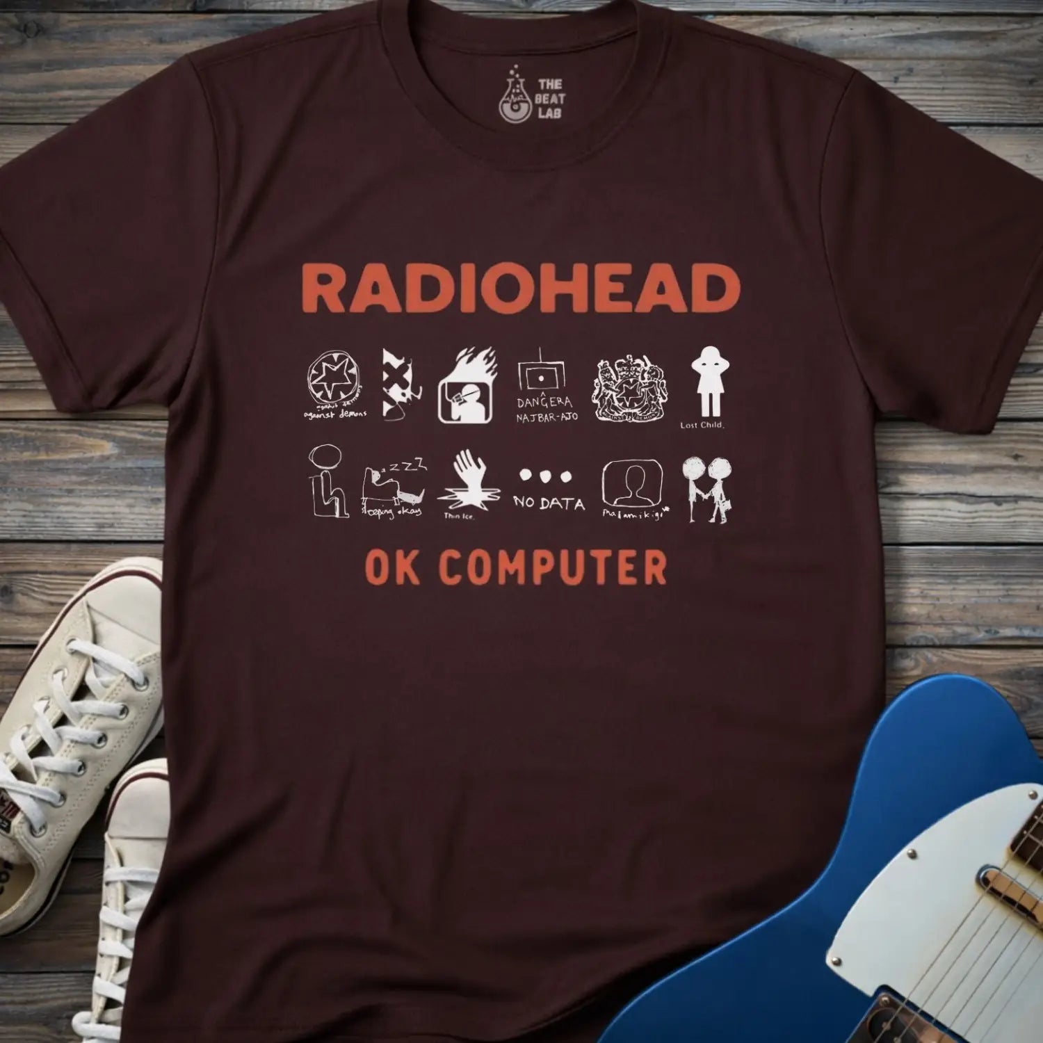 Dark color adult unisex t-shirt gildan 64000 Radiohead OK Computer graphic t-shirt with large RADIOHEAD and OK COMPUTER text and a horizontal row of minimalist white icons in between.