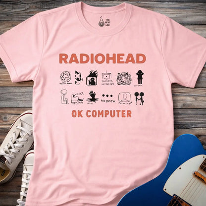 Light Pink color adult unisex t-shirt gildan 64000 Radiohead OK Computer graphic t-shirt with large RADIOHEAD and OK COMPUTER text and a horizontal row of minimalist white icons in between.