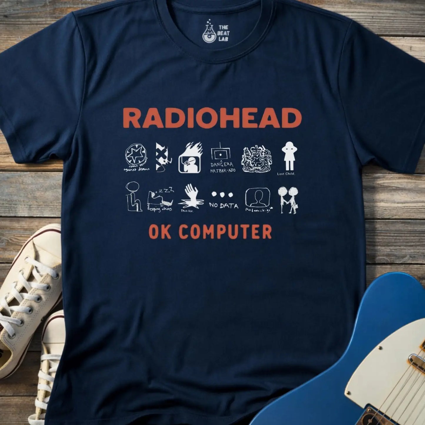 Navy blue color adult unisex t-shirt gildan 64000 Radiohead OK Computer graphic t-shirt with large RADIOHEAD and OK COMPUTER text and a horizontal row of minimalist white icons in between.