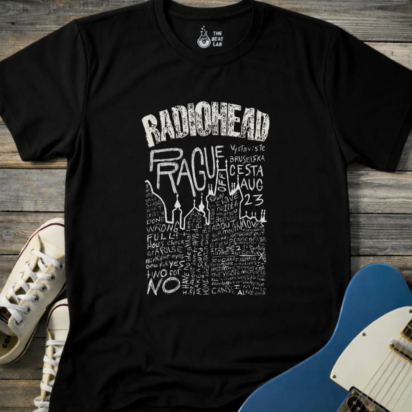 Black color adult unisex t-shirt gildan 64000 Radiohead Prague concert graphic t-shirt with distressed RADIOHEAD header, large hand-drawn PRAGUE text, date details, and dense handwritten lyric-style lettering.
