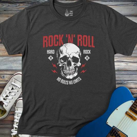 The Rock 'N' Roll 1970 T-shirt features a black design with a skull, red "Rock N Roll" text, "Hard Rock 1970," and "No Rules No Limits" slogans, plus red lightning bolts. Shown beside white sneakers and a blue electric guitar on wood flooring.