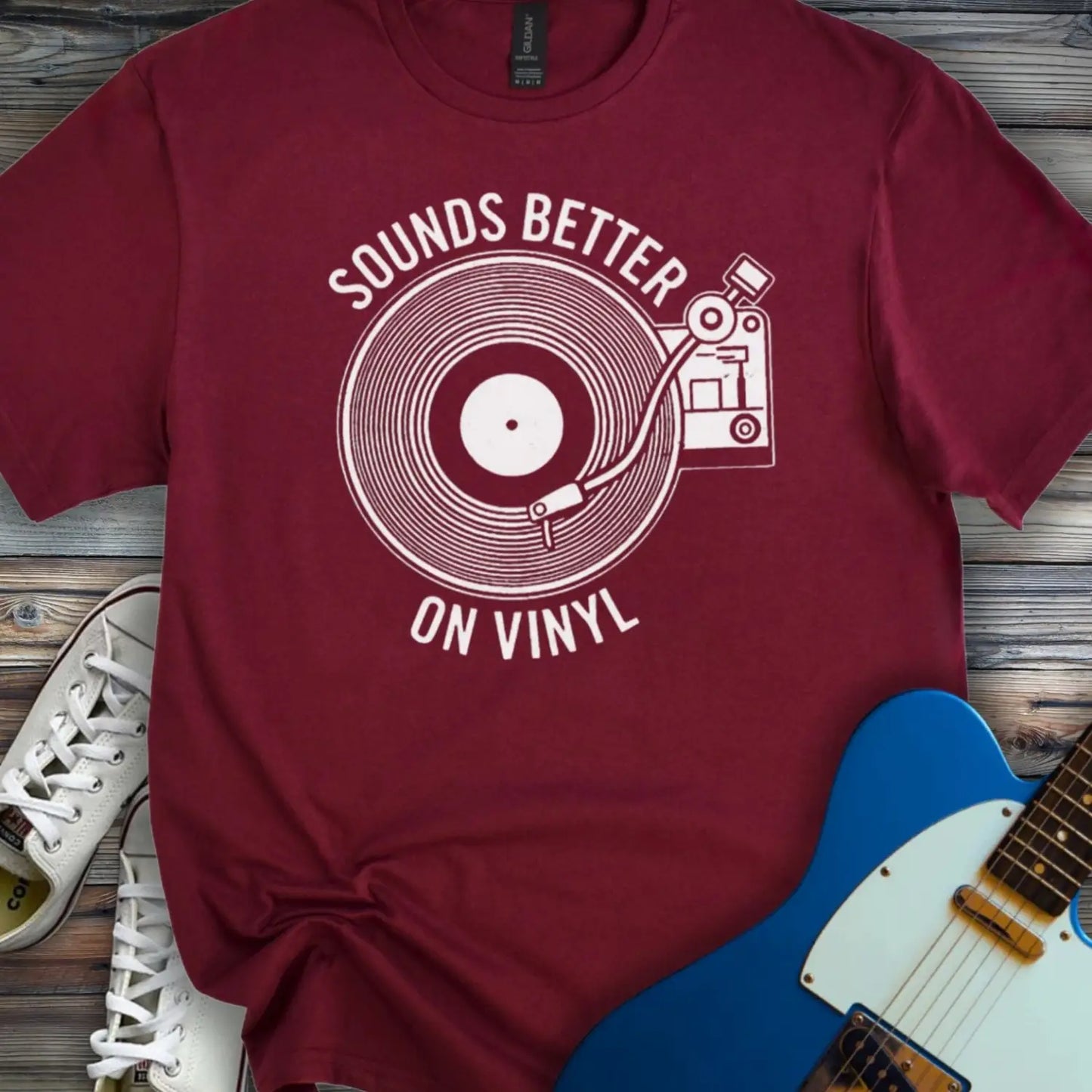 Maroon color of graphic t-shirt with white vinyl record player design and “Sounds Better on Vinyl” music slogan for retro music lovers.