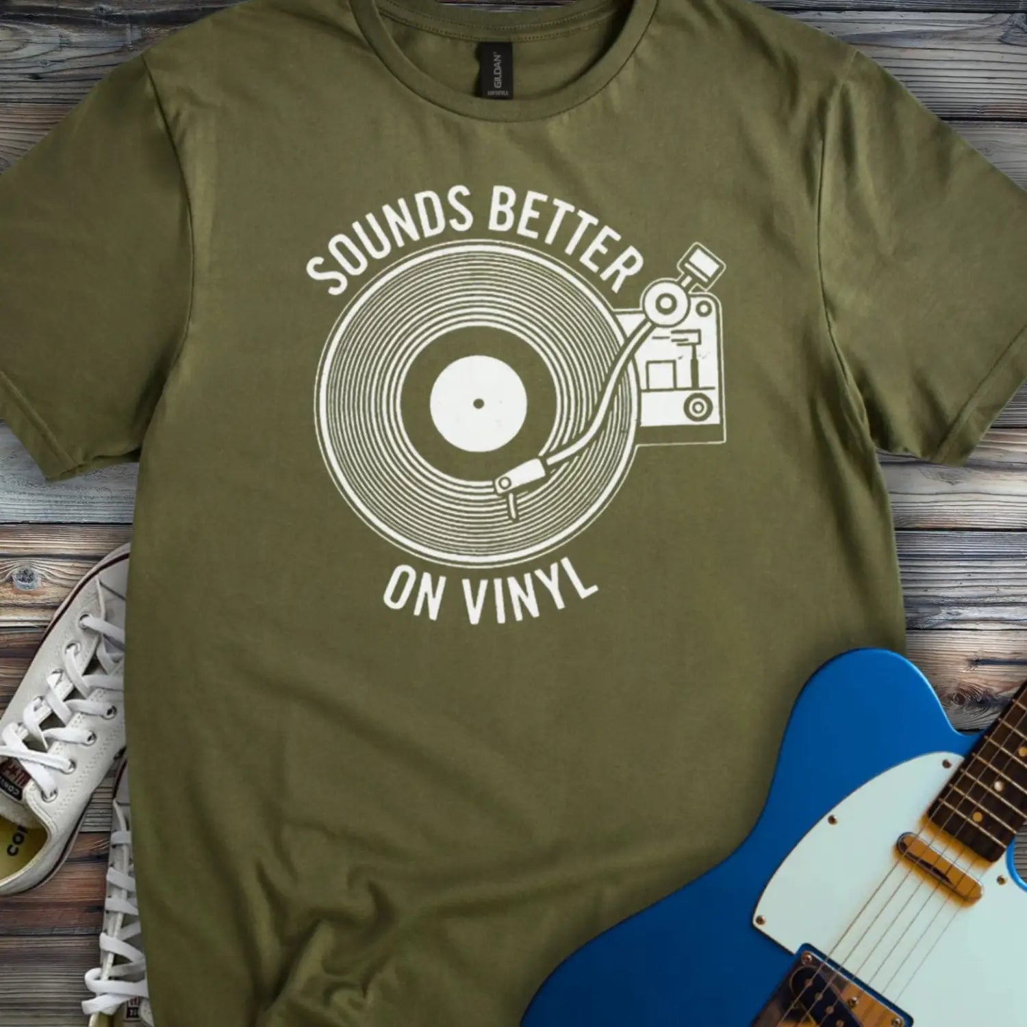 Military Green color of graphic t-shirt with white vinyl record player design and “Sounds Better on Vinyl” music slogan for retro music lovers.