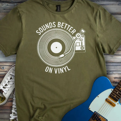 Military Green color of graphic t-shirt with white vinyl record player design and “Sounds Better on Vinyl” music slogan for retro music lovers.