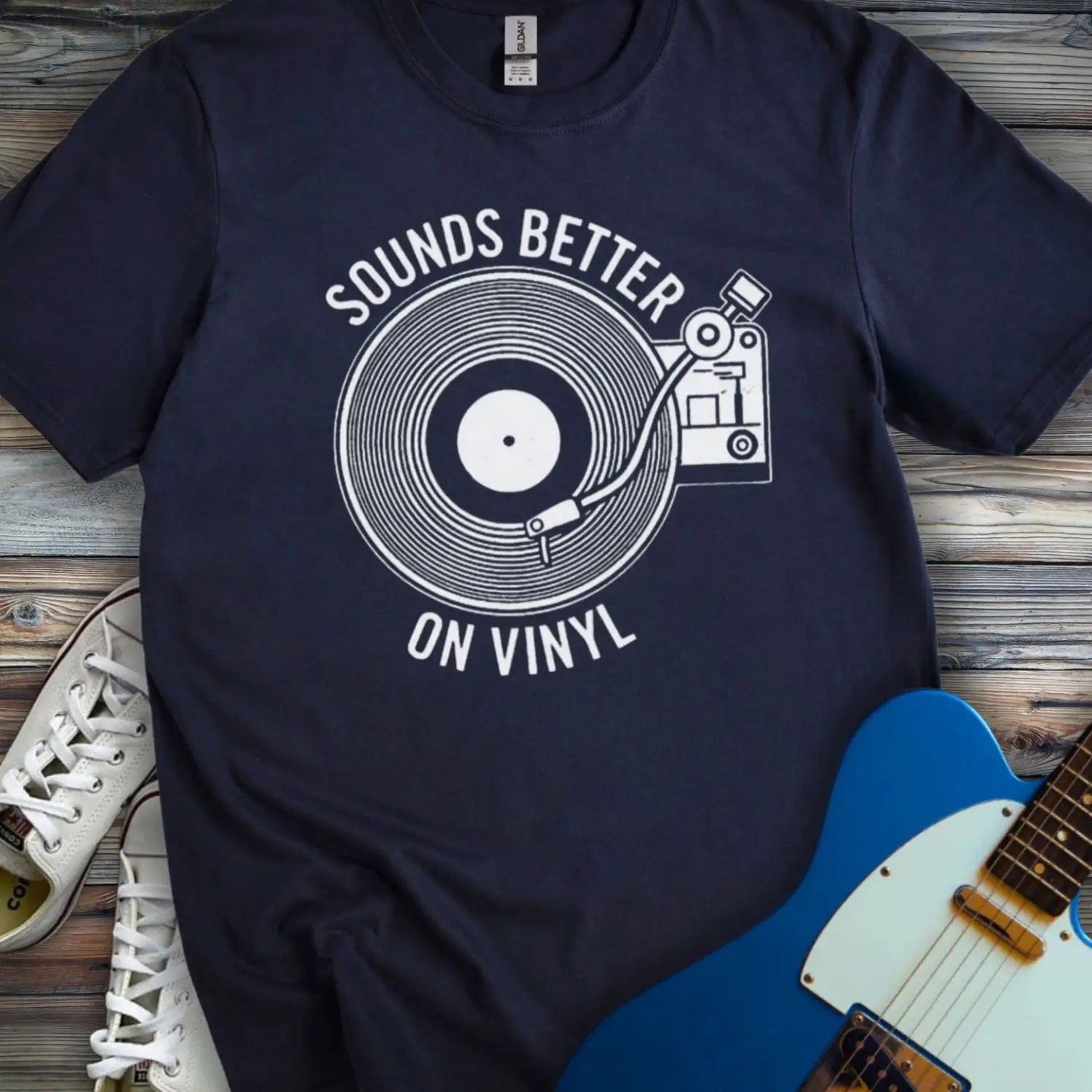 Navy blue color of graphic t-shirt with white vinyl record player design and “Sounds Better on Vinyl” music slogan for retro music lovers.