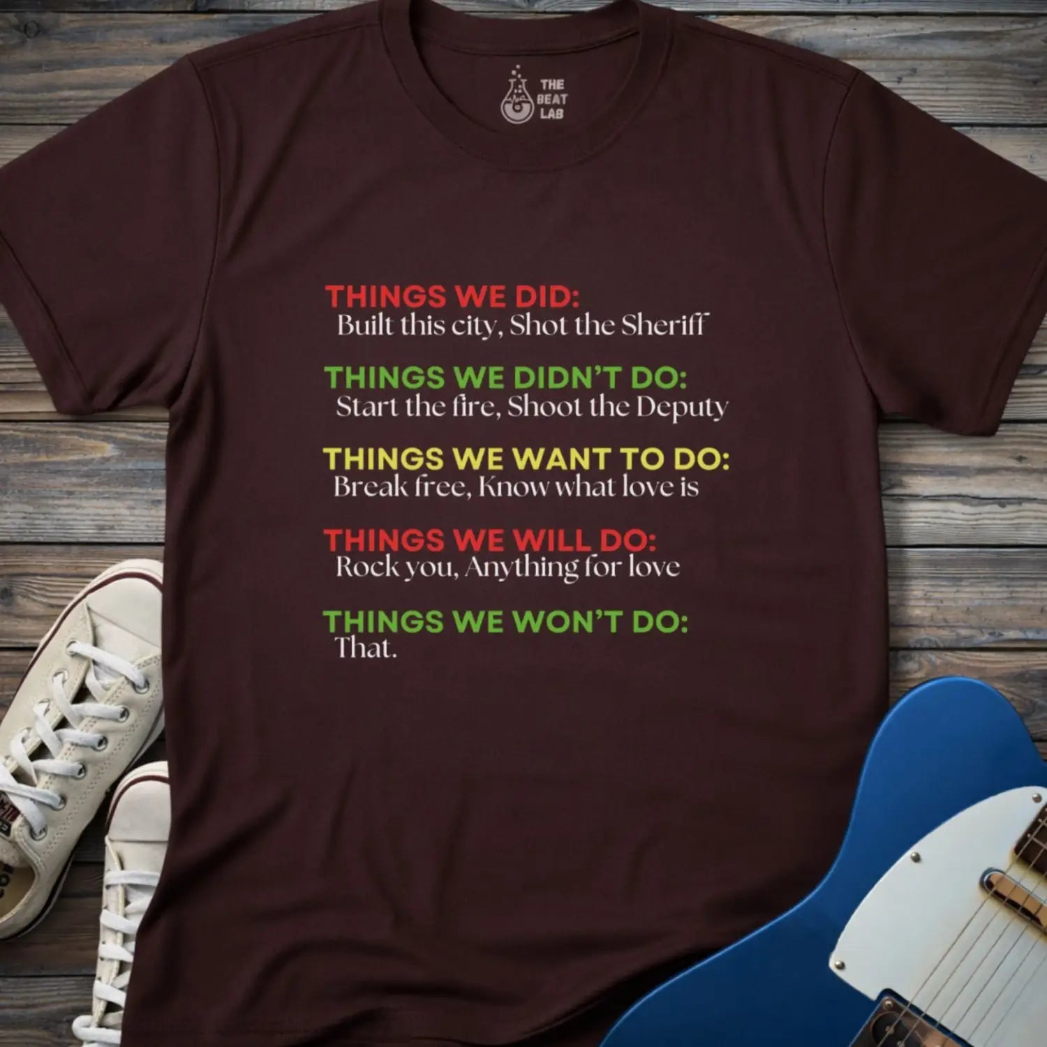 Dark chocolate color men women gildan 64000 shirt featuring graphic text of funny rock lyrics things we did, built this city, shot the sheriff, start the fire, shoot the deputy. Funny nostalgic rock music lyrics shirt.